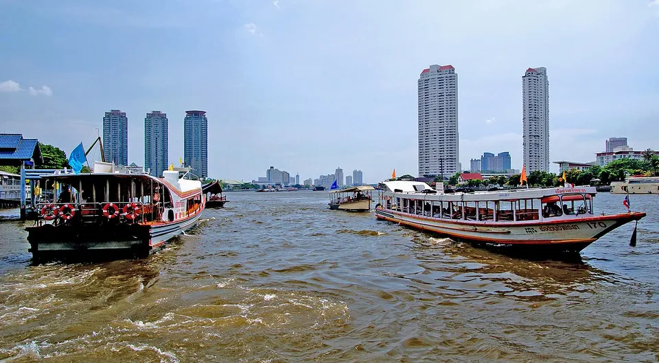 Boats on a river beside the city — Bangkok, Thailand