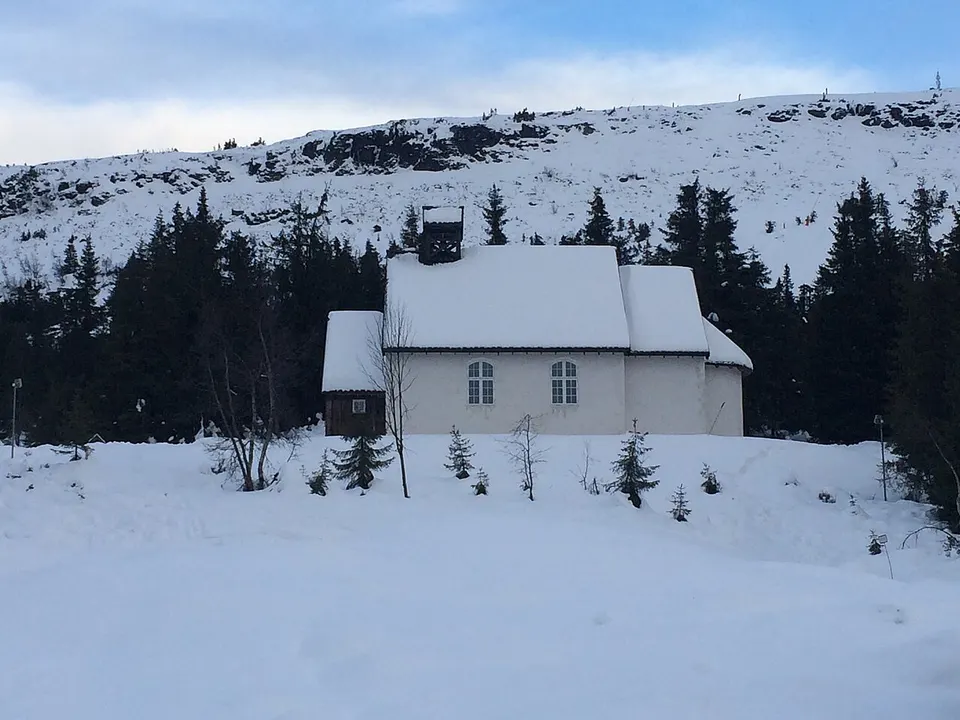 Snow-covered cabin and mountain landscape — Innlandet, Norway