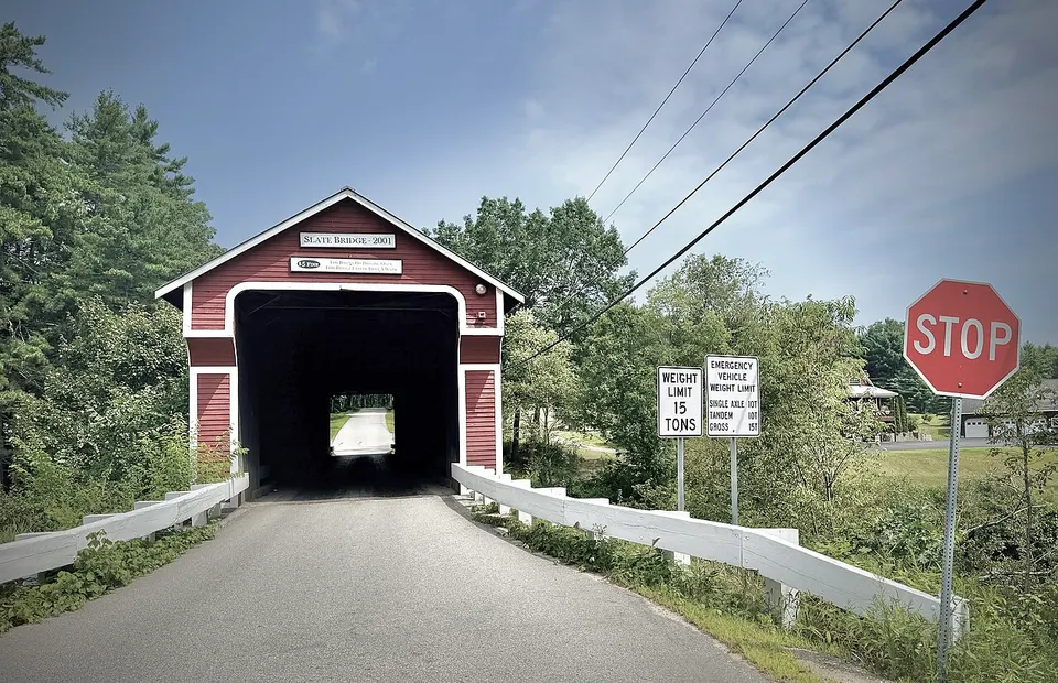 The red-colored Slate Covered Bridge (2001) spans the Ashuelot River near Westport, New Hampshire, U.S.A. (2025).2 — Cheshire, United States